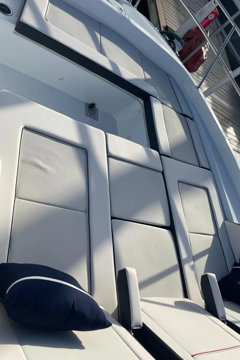 Slide: The Image of 2025 Jeanneau Leader 12.5 WA boat with cushioned seating and sleek design. - 24