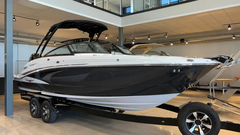 The Image of 2025 Monterey M65 boat on display in a showroom, featuring sleek black and white design. - 0