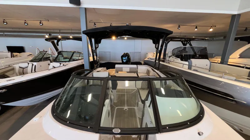 Slide: The Image of 2025 Monterey M65 boat displayed in a showroom with other luxury boats. - 14