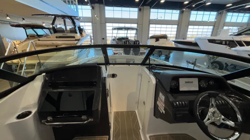 Slide: The Image of Interior view of 2025 Monterey M65 boat in showroom, featuring modern dashboard and steering wheel. - 25