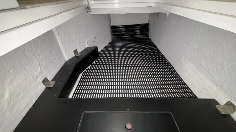 Slide: The Image of Interior view of 2025 Monterey M65 storage compartment with black grid flooring. - 27