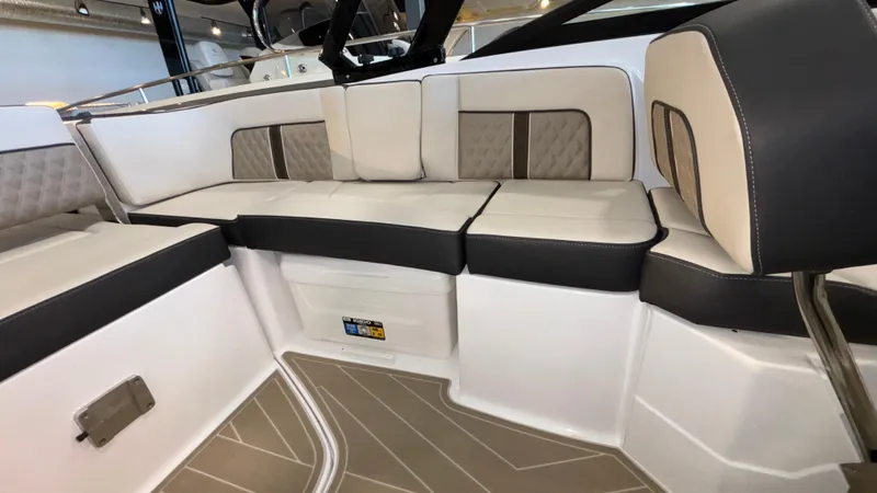 Slide: The Image of 2025 Monterey M65 boat interior with beige and black cushioned seating. - 30