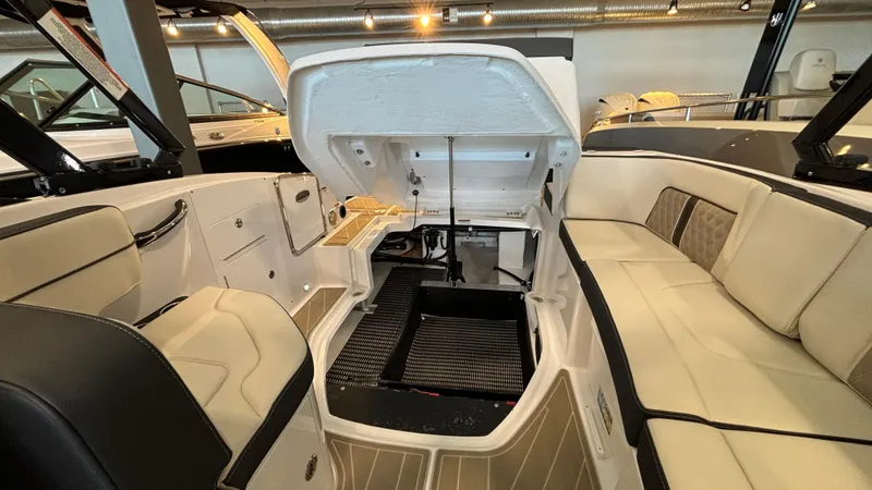 Slide: The Image of 2025 Monterey M65 boat interior with open engine compartment and beige seating. - 37