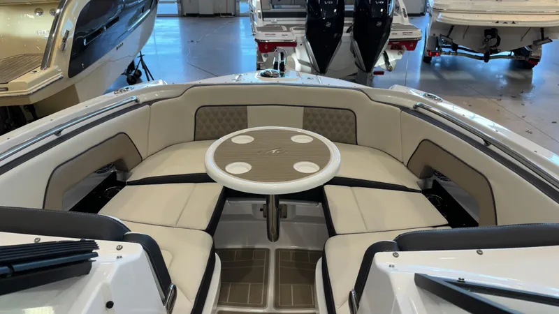 Slide: The Image of 2025 Monterey M65 boat interior with circular seating and table in showroom. - 42