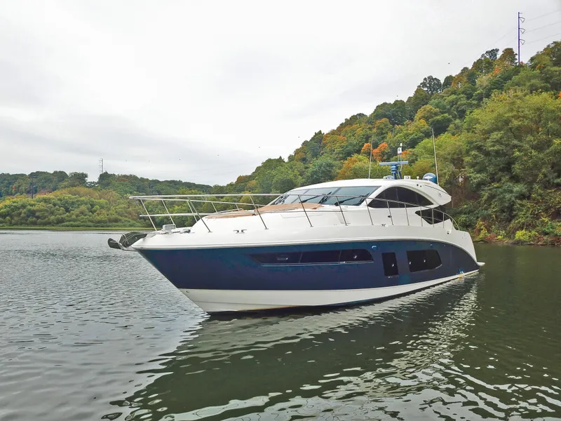 Slide: The Image of 2016 Sea Ray L650 yacht cruising on a serene lake with lush green hills. - 10