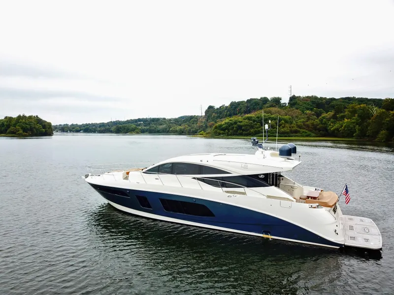 Slide: The Image of 2016 Sea Ray L650 yacht cruising on a serene lake with lush green shoreline. - 11