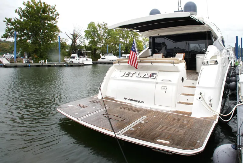 Slide: The Image of 2016 Sea Ray L650 yacht docked, featuring a spacious deck and American flag. - 20