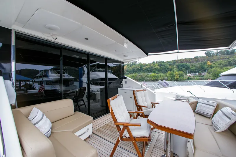 Slide: The Image of Luxurious 2016 Sea Ray L650 yacht deck with seating and table, overlooking marina. - 23