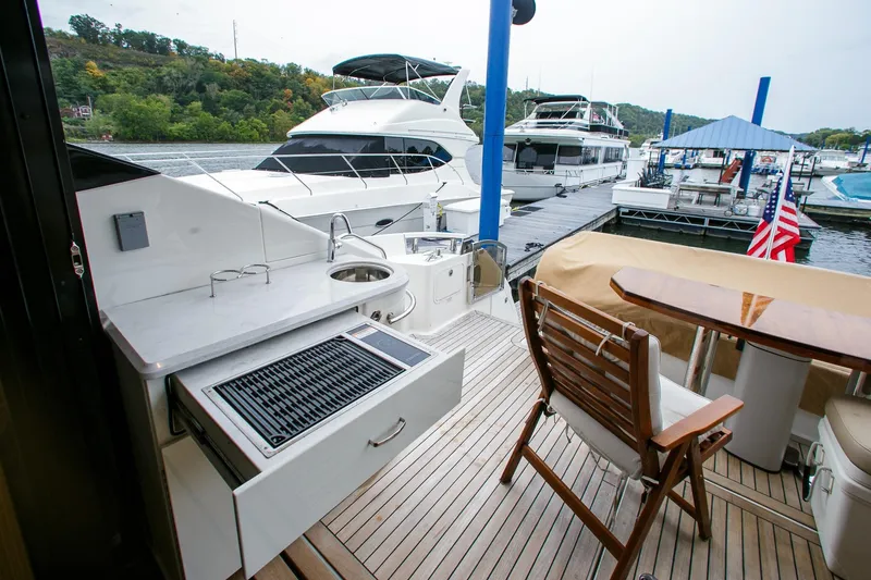Slide: The Image of 2016 Sea Ray L650 yacht deck with grill, seating, and marina view. - 24