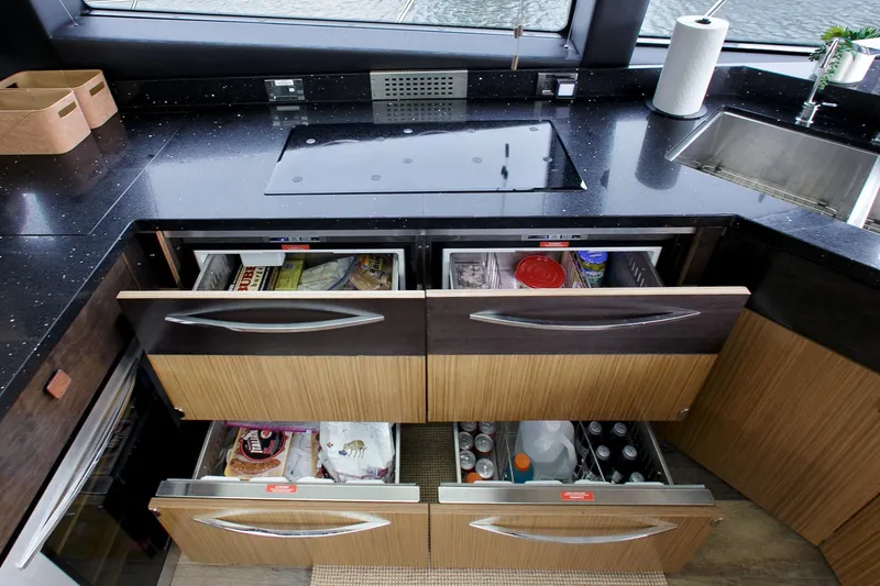 Slide: The Image of Modern kitchen on 2016 Sea Ray L650 yacht with open drawers and sleek countertops. - 38