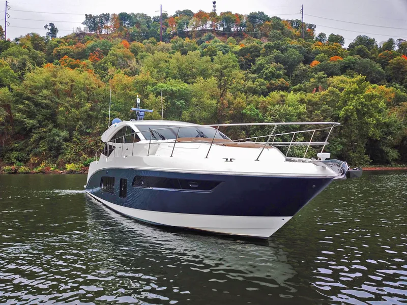 Slide: The Image of 2016 Sea Ray L650 yacht cruising on a scenic lake with lush green trees. - 9