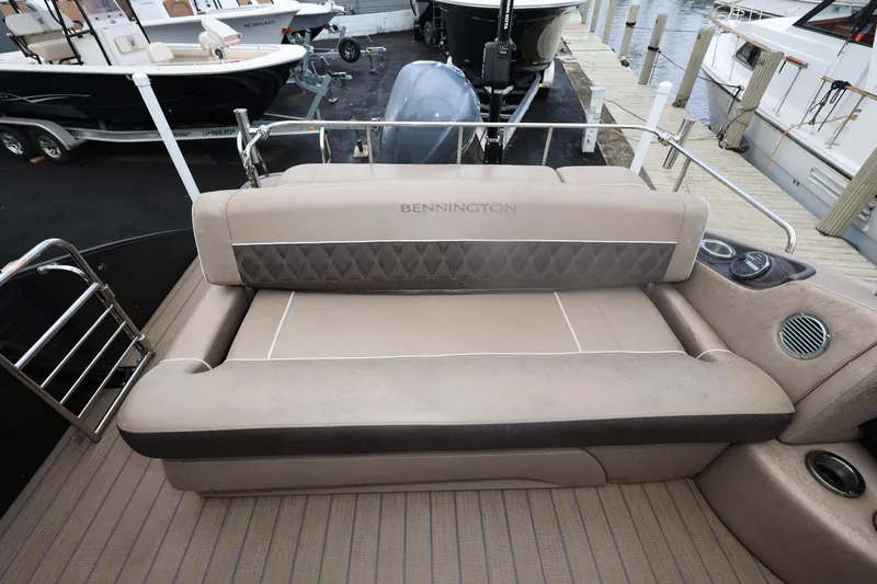 Slide: The Image of 2019 Bennington R 23 RSBA boat interior with beige seating and dock view. - 13