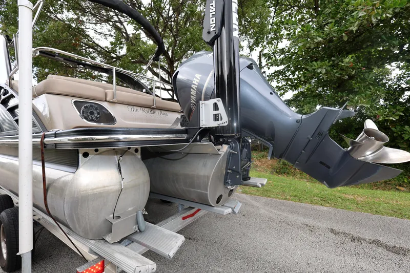 Slide: The Image of 2019 Bennington R 23 RSBA pontoon boat on trailer, featuring powerful outboard motor. - 3