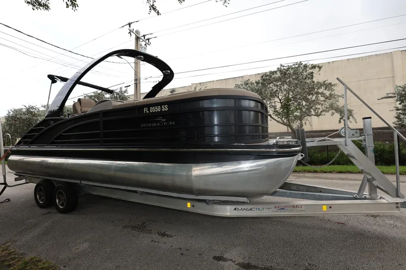 Slide: The Image of 2019 Bennington R 23 RSBA pontoon boat on trailer, parked outdoors. - 7