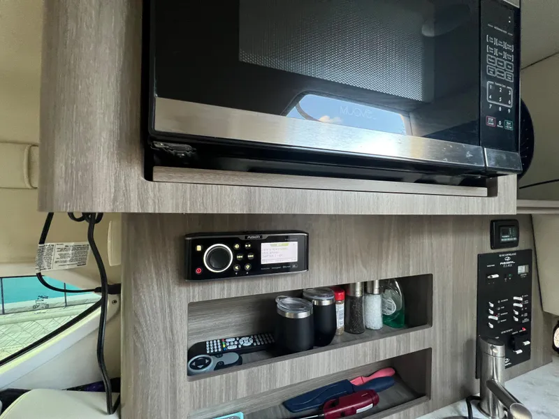 Slide: The Image of 2020 Regal 26 XO boat interior with microwave, radio, and storage shelves. - 37