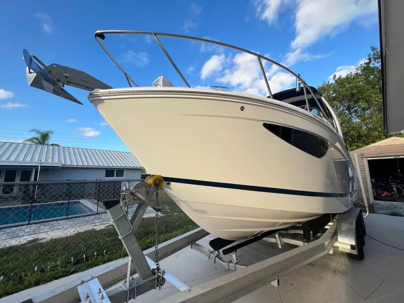 Slide: The Image of 2020 Regal 26 XO boat on trailer, parked outdoors under blue sky. - 4