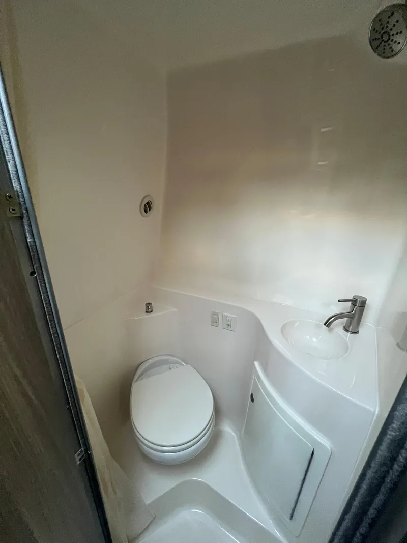 Slide: The Image of 2020 Regal 26 XO boat bathroom with toilet, sink, and showerhead. - 43
