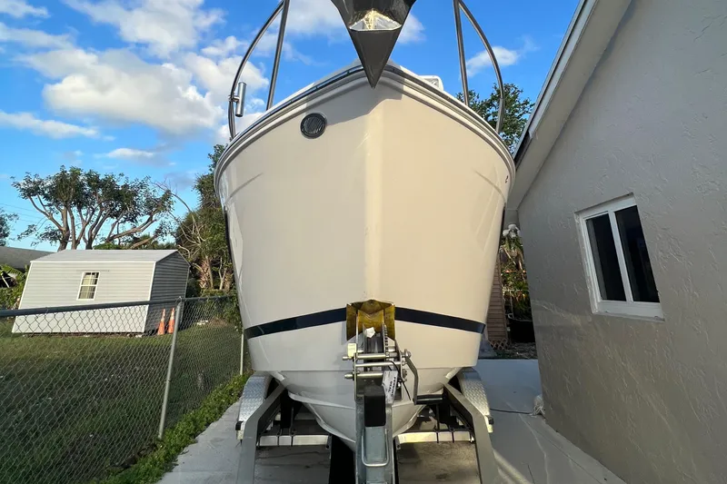 Slide: The Image of 2020 Regal 26 XO boat on trailer, parked beside a house under a blue sky. - 7