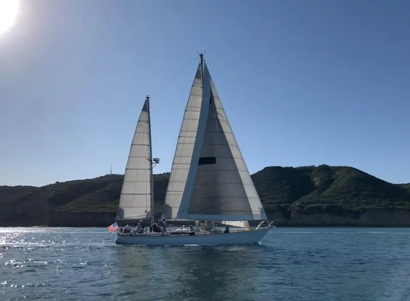 Slide: The Image of Sailboat Skye 51 Ketch Kaufman & Ladd 1980 sailing near coastal cliffs. - 1