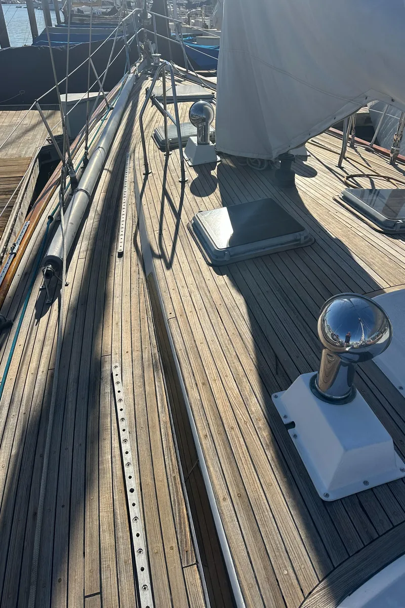 Slide: The Image of 1980 Skye 51 Ketch sailboat deck with wooden finish and rigging details. - 16