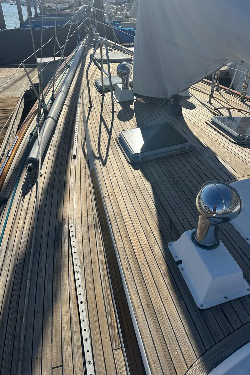 Slide: The Image of 1980 Skye 51 Ketch sailboat deck with wooden finish and rigging details. - 18