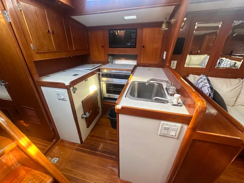 Slide: The Image of Interior of 1980 Skye 51 Ketch sailboat kitchen with wood cabinetry and modern appliances. - 20