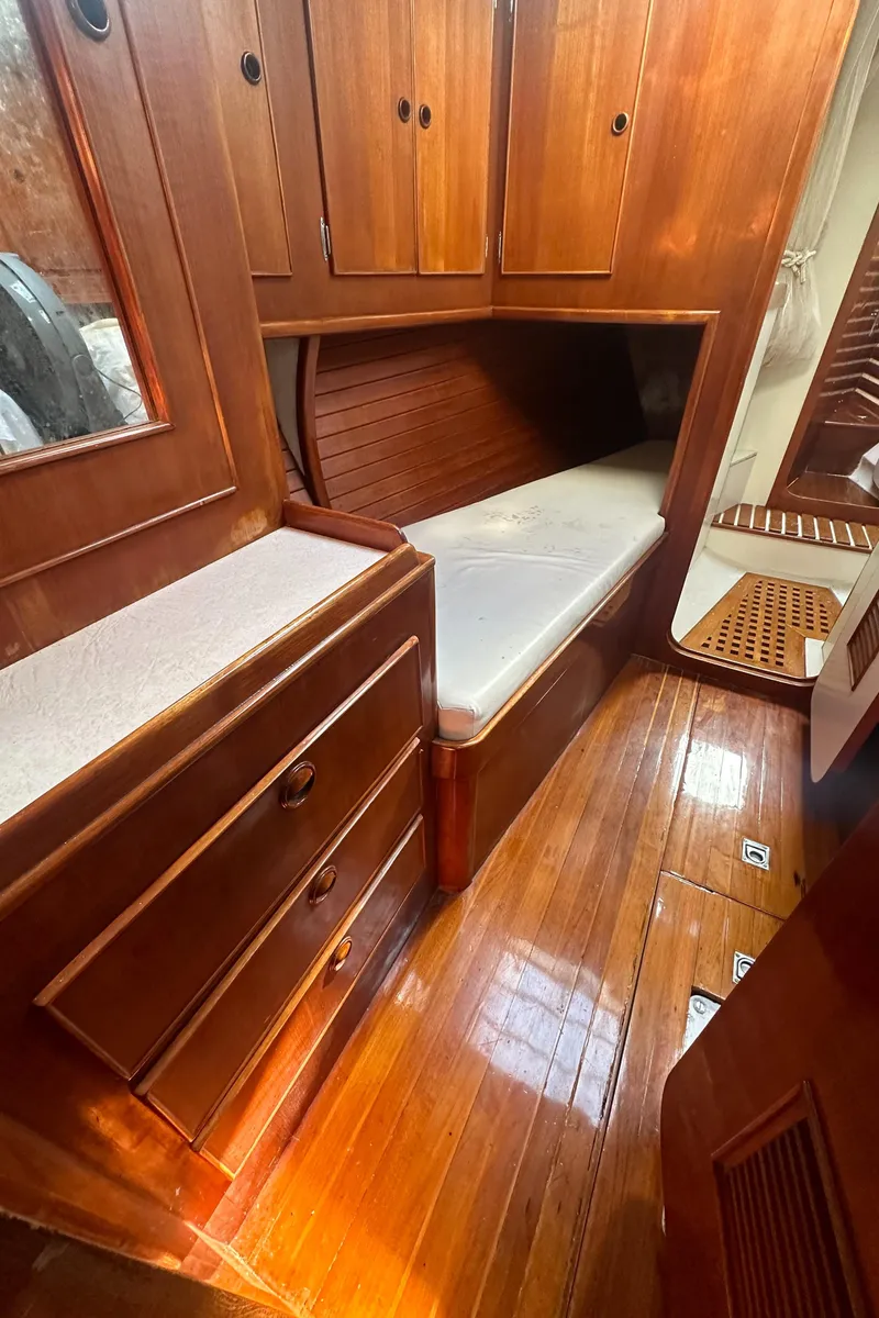 Slide: The Image of 1980 Skye 51 Ketch sailboat cabin with wooden interior and cozy sleeping area. - 25