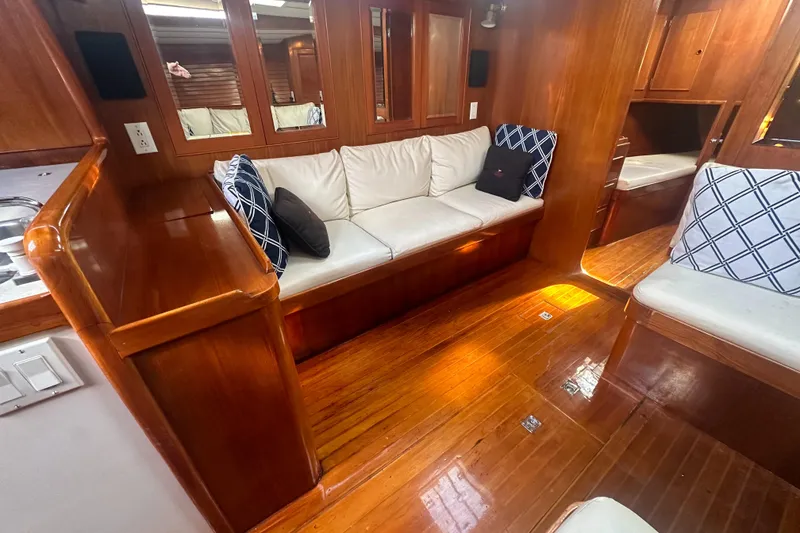 Slide: The Image of Interior of 1980 Skye 51 Ketch sailboat with wooden flooring and cushioned seating. - 26