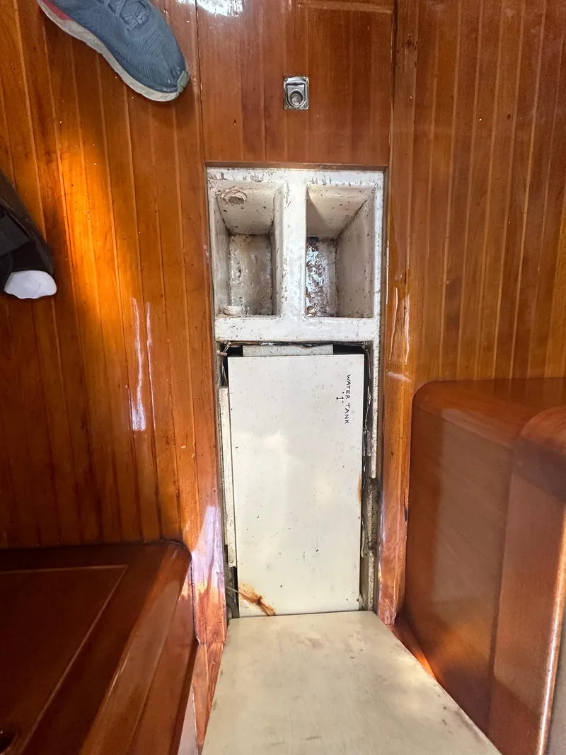 Slide: The Image of Interior of 1980 Skye 51 Ketch sailboat with wooden paneling and storage compartment. - 27