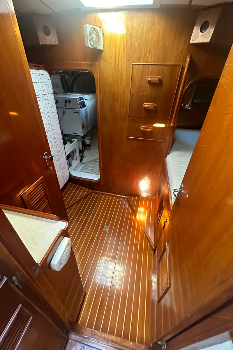 Slide: The Image of 1980 Skye 51 Ketch sailboat interior with wooden flooring and cozy cabin space. - 30