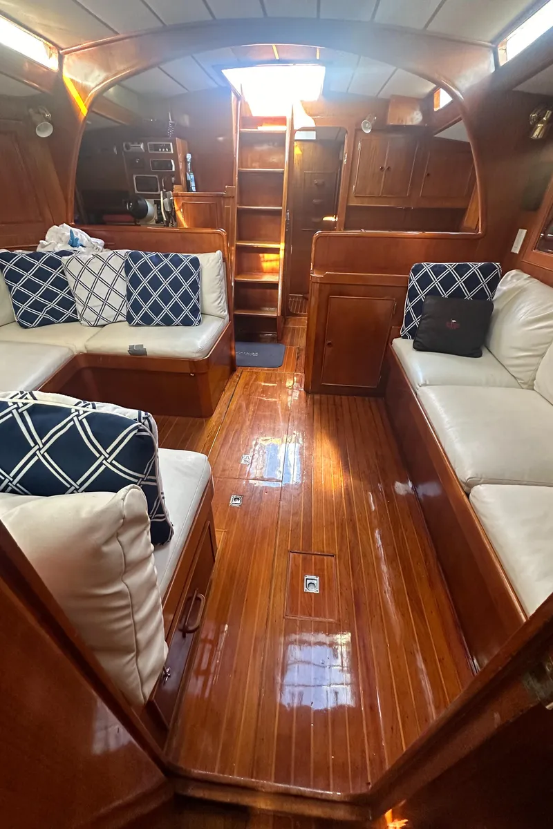 Slide: The Image of Interior of 1980 Skye 51 Ketch sailboat with polished wood and cushioned seating. - 33