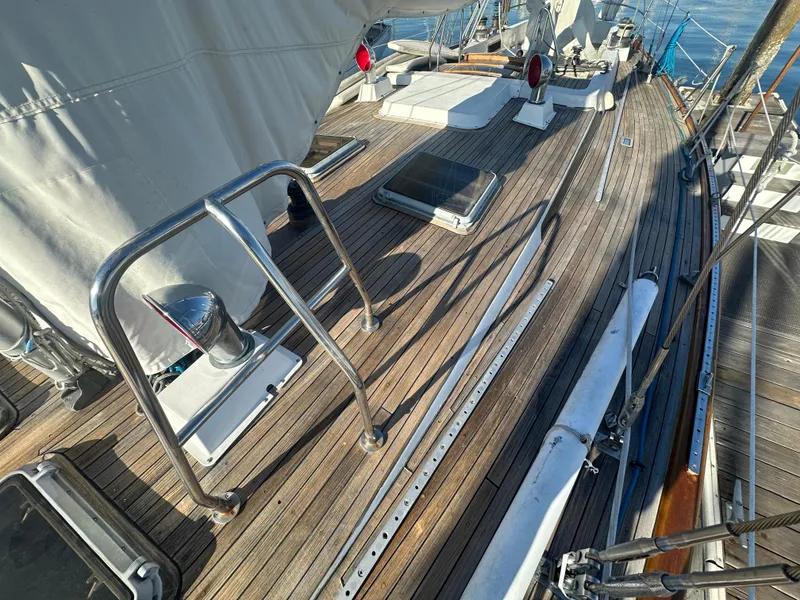 Slide: The Image of 1980 Skye 51 Ketch sailboat deck with wooden finish and metal railings. - 34