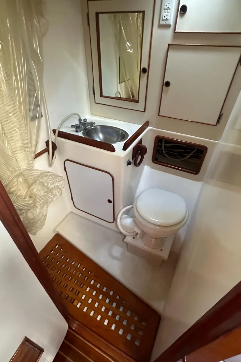 Slide: The Image of 1980 Skye 51 Ketch sailboat bathroom with sink, toilet, and wooden floor mat. - 35