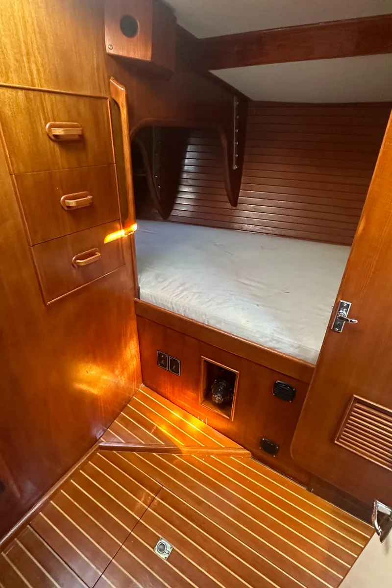 Slide: The Image of Interior of 1980 Skye 51 Ketch sailboat with wooden paneling and cozy sleeping area. - 36
