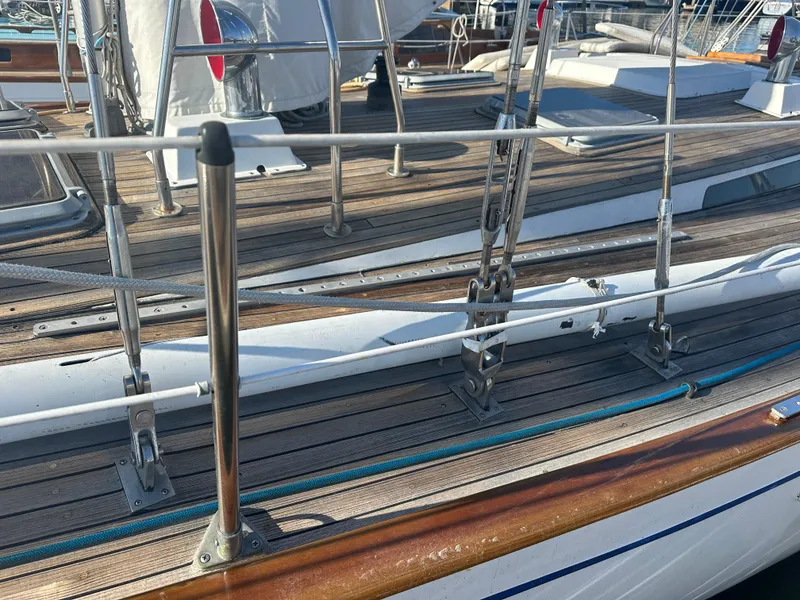Slide: The Image of 1980 Skye 51 Ketch sailboat deck with wooden finish and metal railings. - 6