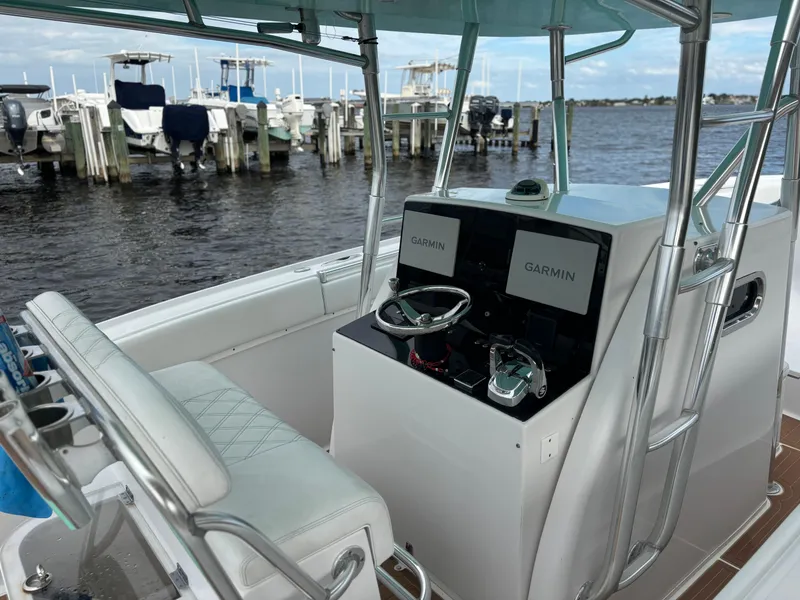 Slide: The Image of 2006 Buddy Davis 34 Center Console boat with Garmin displays at a marina. - 11