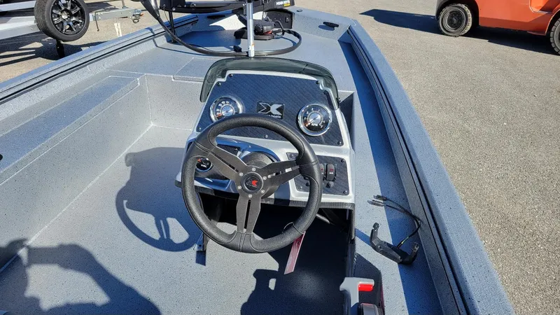 Slide: The Image of 2025 Xpress XP180 Bass boat interior with steering wheel and dashboard controls. - 11