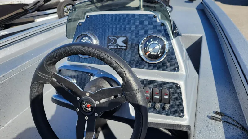 Slide: The Image of 2025 Xpress XP180 Bass boat dashboard with steering wheel and gauges. - 6