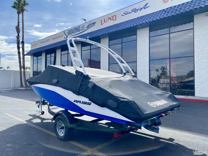 Slide: The Image of 2024 Yamaha AR195 boat with cover, parked outside a dealership. - 3