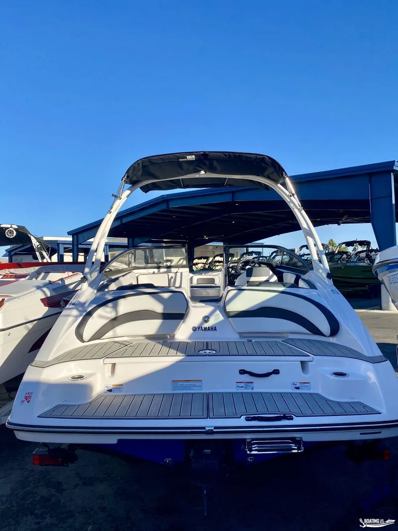 Slide: The Image of 2024 Yamaha AR195 boat, rear view, in a marina under clear blue sky. - 6
