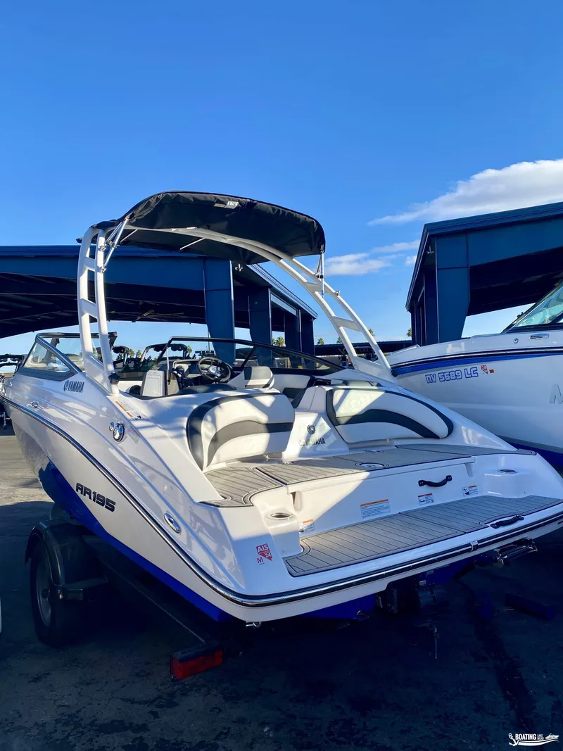 Slide: The Image of 2024 Yamaha AR195 boat with sleek design, parked under clear blue sky. - 7