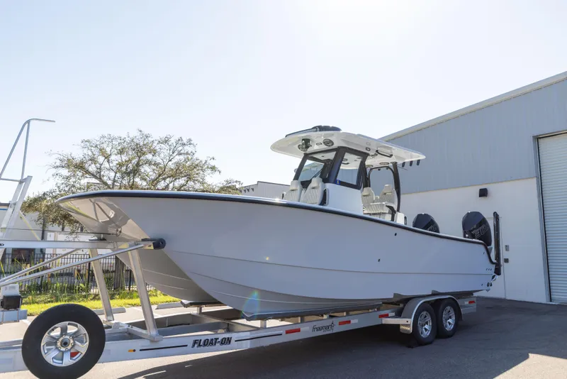 Slide: The Image of 2024 Freeman 28 boat on trailer outside a warehouse. - 1