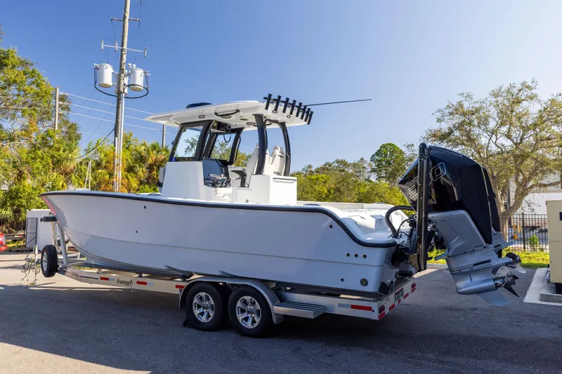 Slide: The Image of 2024 Freeman 28 boat on trailer, parked outdoors, clear sky background. - 2