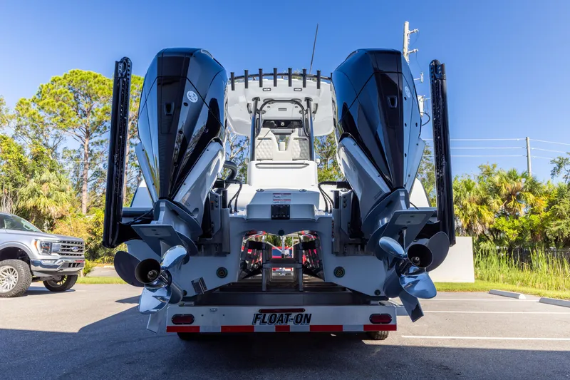 Slide: The Image of 2024 Freeman 28 boat with dual engines on a trailer, parked outdoors. - 4