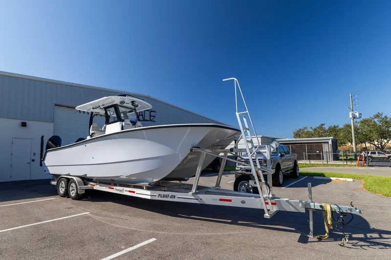 Slide: The Image of 2024 Freeman 28 boat on trailer in parking lot, clear blue sky. - 6
