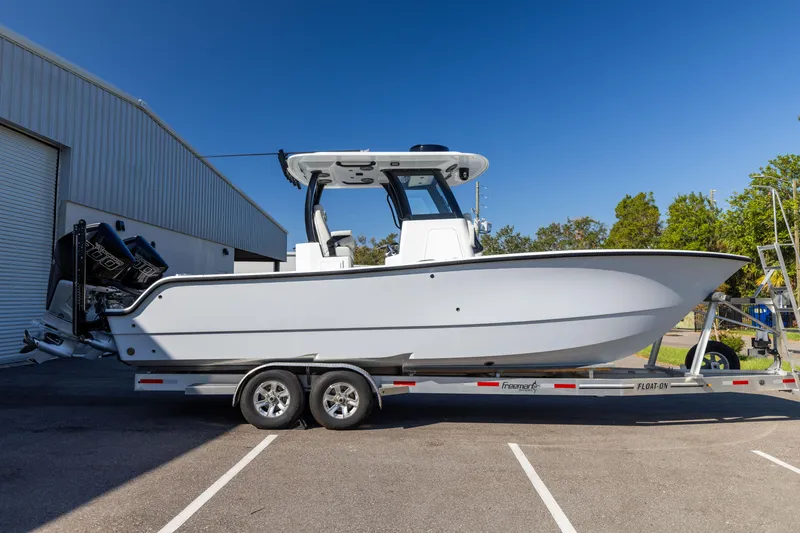 Slide: The Image of 2024 Freeman 28 boat on trailer, parked outside a warehouse. - 7