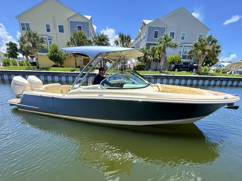 Slide: The Image of 2025 Chris-Craft Calypso 28 boat on water, with modern design and dual Mercury engines. - 0