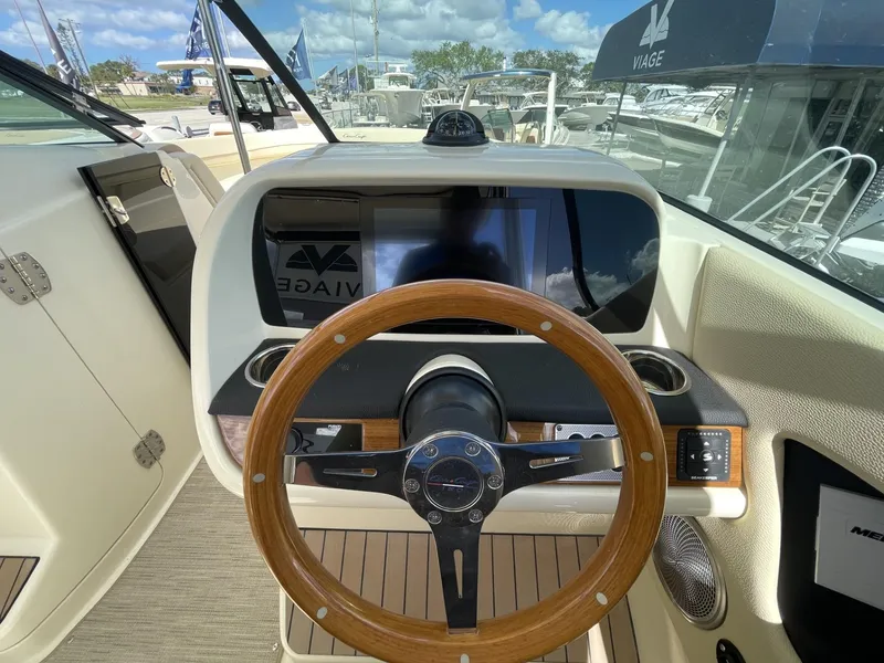 Slide: The Image of 2025 Chris-Craft Calypso 28 helm with wooden steering wheel and modern dashboard. - 12