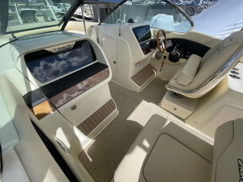 Slide: The Image of 2025 Chris-Craft Calypso 28 boat interior with elegant seating and modern dashboard. - 13