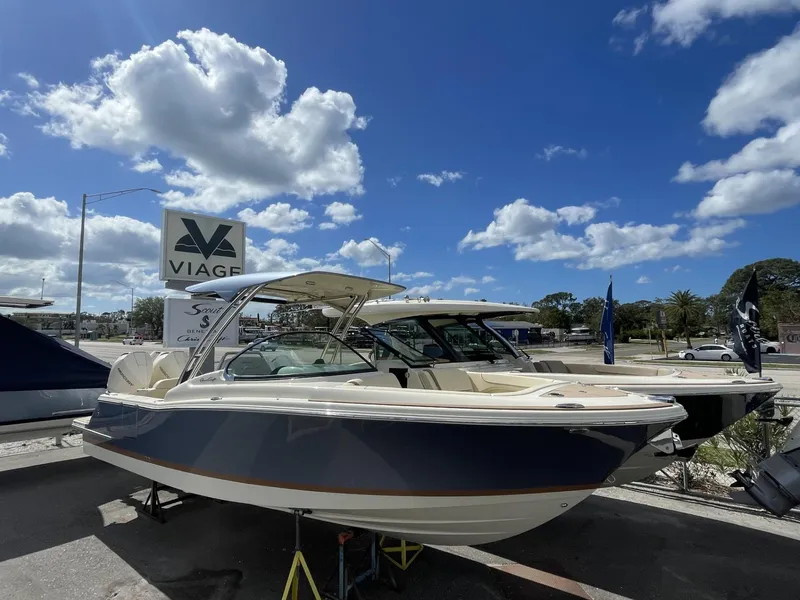 Slide: The Image of 2025 Chris-Craft Calypso 28 boat displayed outdoors under a blue sky. - 2